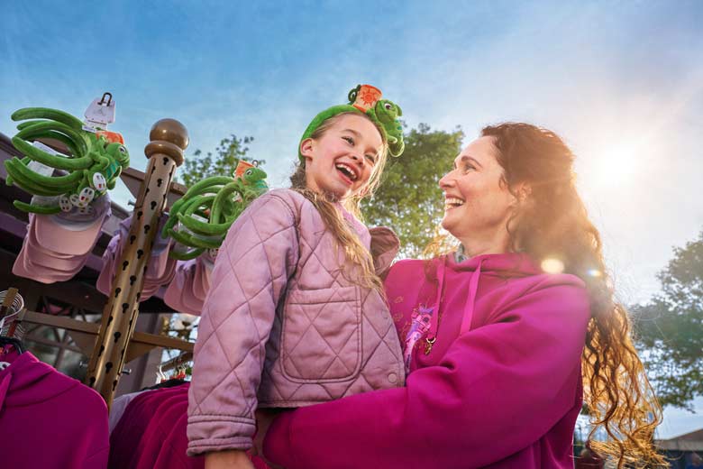 DISNEYLAND&reg; PARIS Adventure World, a parent smiles at an excited child as they enter the park